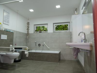 Ein behindertengerechtes Badezimmer mit Toilette, Badewanne und Waschbecken