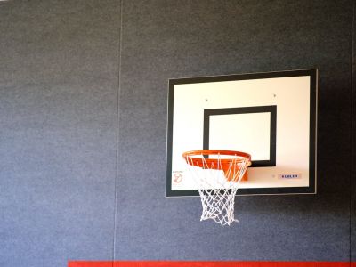 Ein Basketballkorb hängt in einer Turnhalle