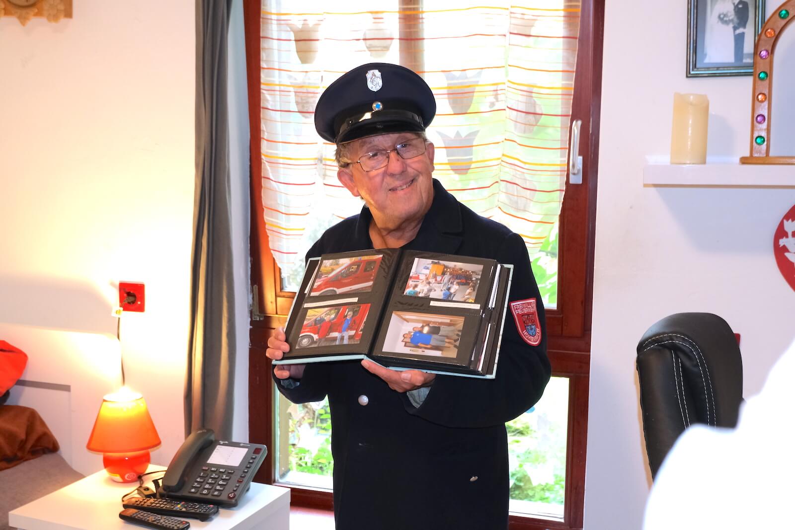 Stolzes Mitgleid der freiwilligen Feuerwehr zeigt sein Fotoalbum